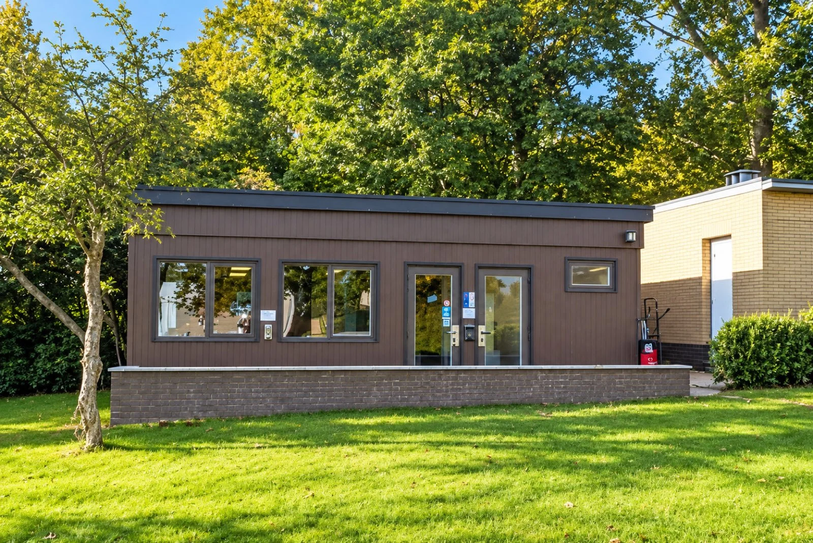Boei 165, een klein gebouw met grote ramen in een groene tuin